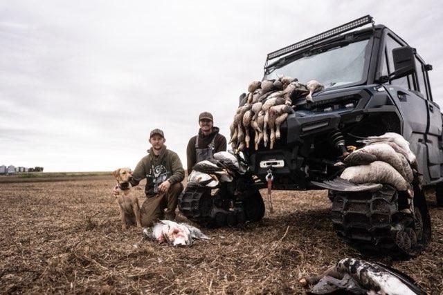 Guide with retriever and stacked birds on the side-by-side